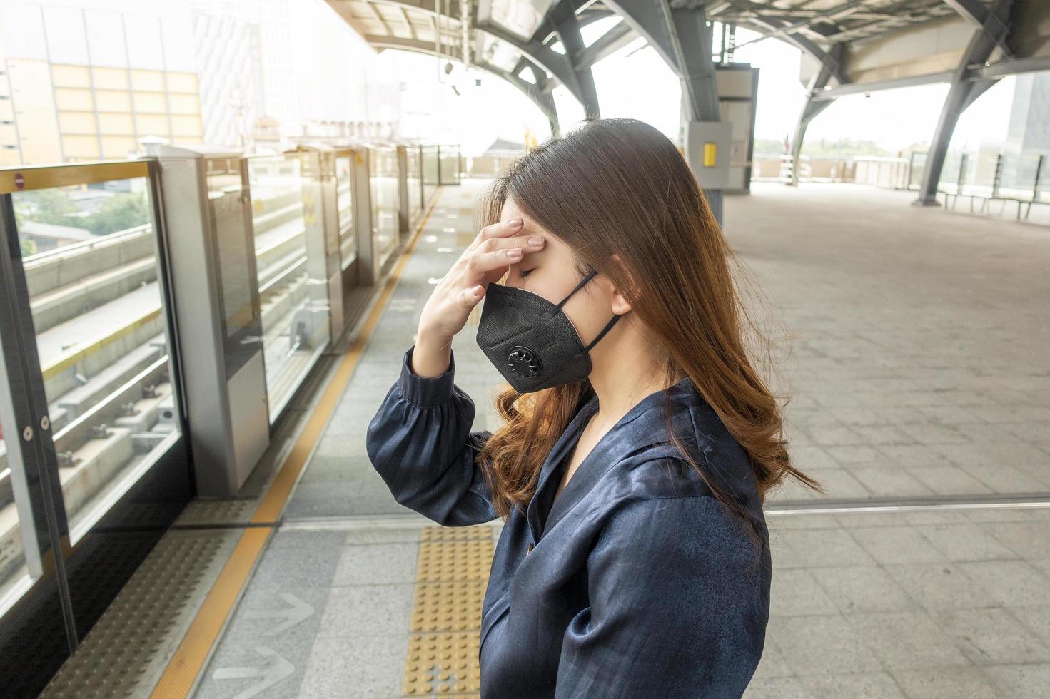 hermosa mujer con máscara antipolvo protege la contaminación del aire y pm 2.5 en la ciudad de la calle foto