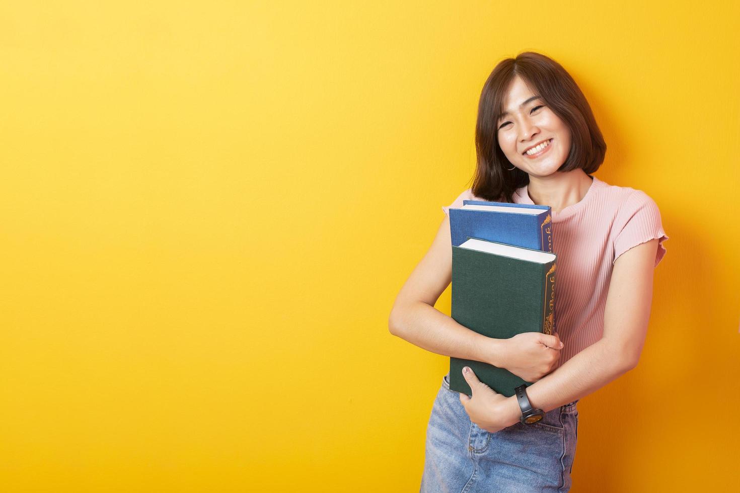 bella estudiante universitaria asiática feliz con antecedentes amarillos foto