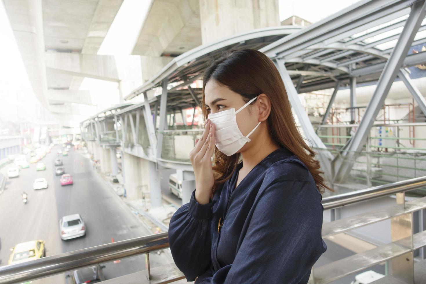 hermosa mujer con máscara antipolvo protege la contaminación del aire y pm 2.5 en la ciudad de la calle foto