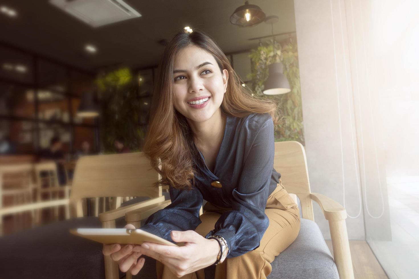 Beautiful woman is working with tablet in coffee shop photo