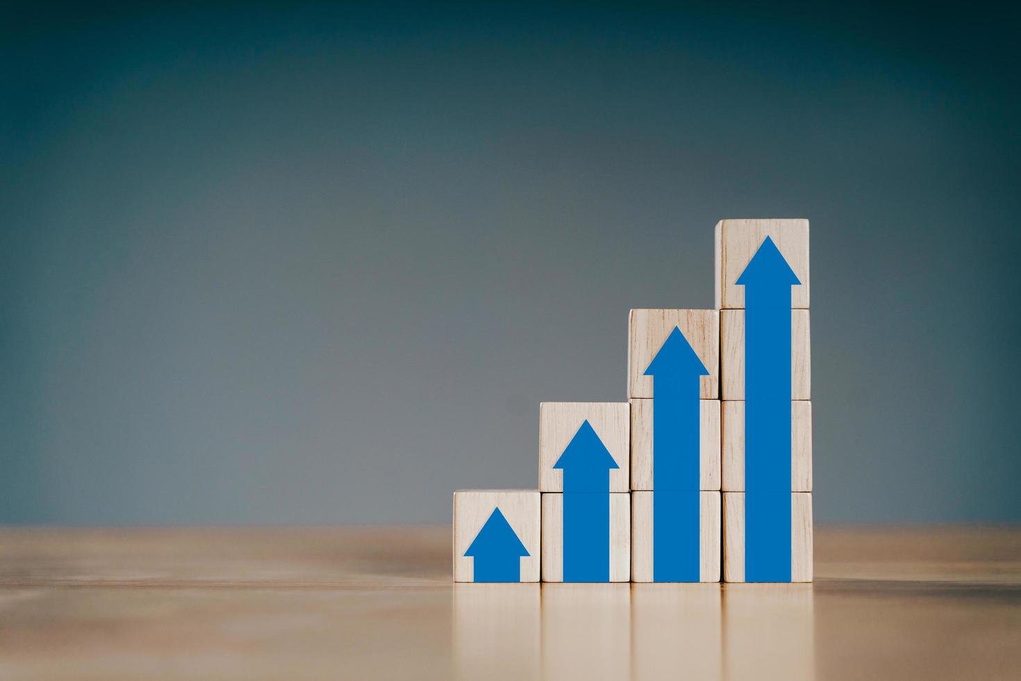 Stack of wooden blocks with growing arrow up graphs. Business development to success and growing growth concept. photo