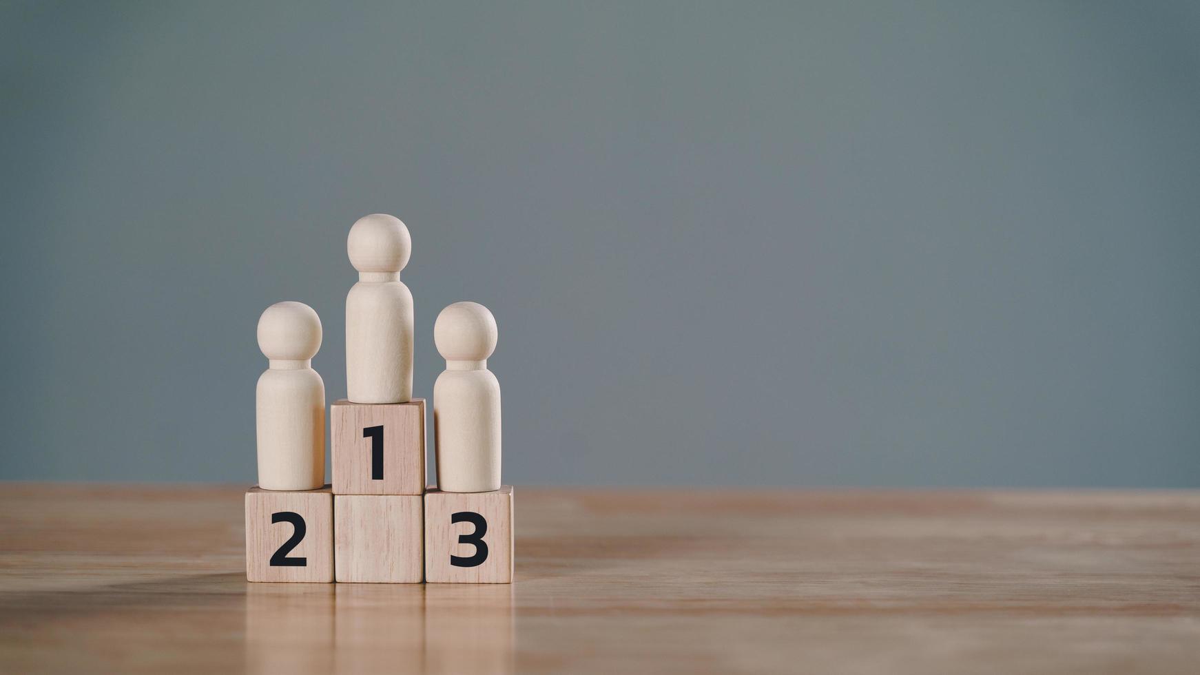 wooden figures peg doll standing on the podium 1st, 2nd, 3rd positions of wooden cube blocks with copy space. ranking and strategy concept. photo