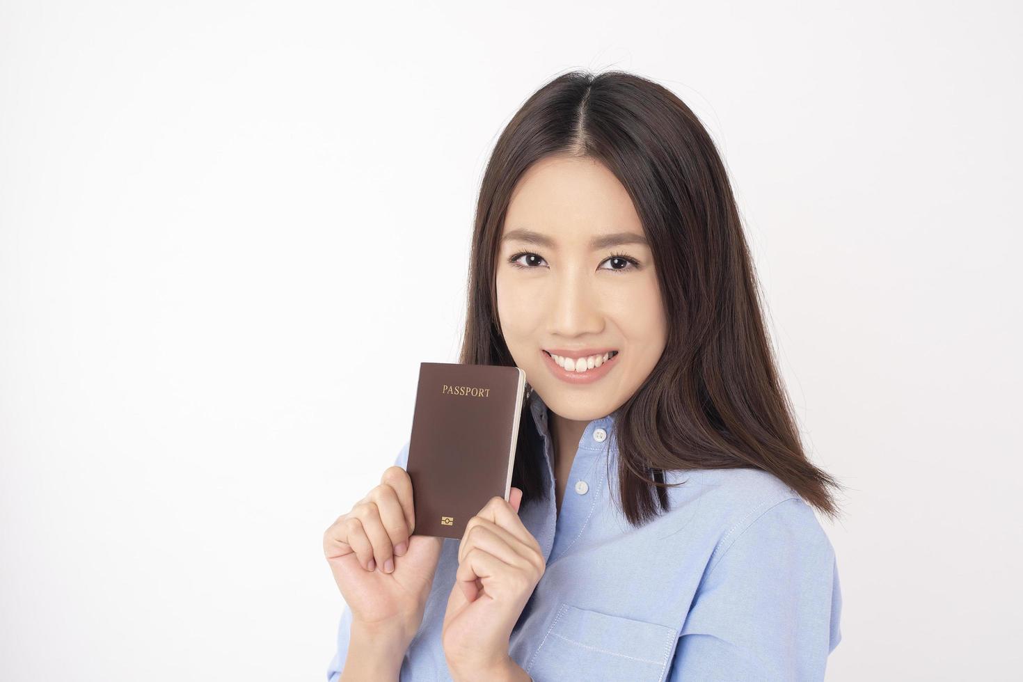 hermosa mujer asiática turista tiene pasaporte sobre fondo blanco foto