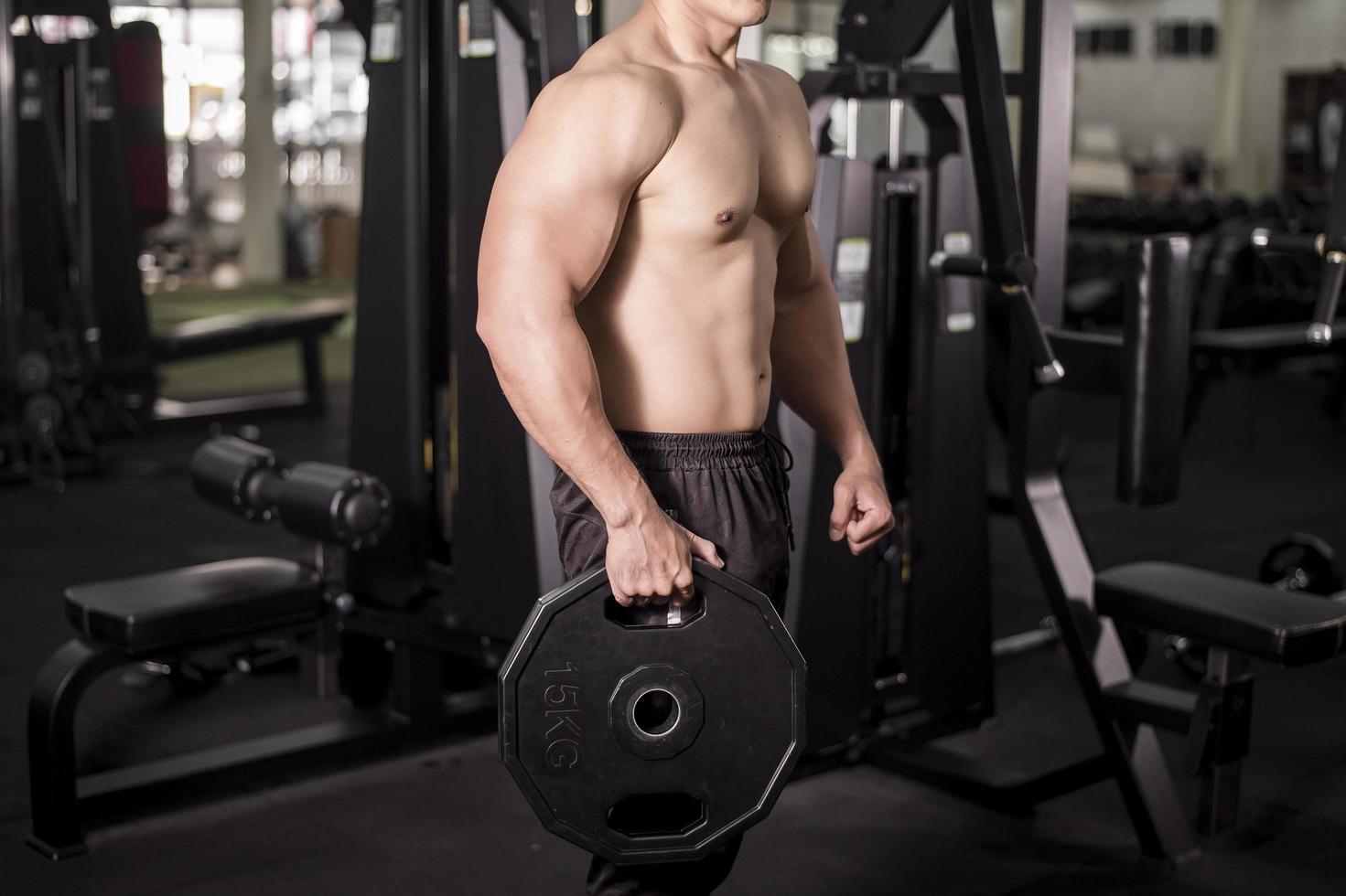 Muscular fitness hombre culturista está entrenando en el gimnasio foto