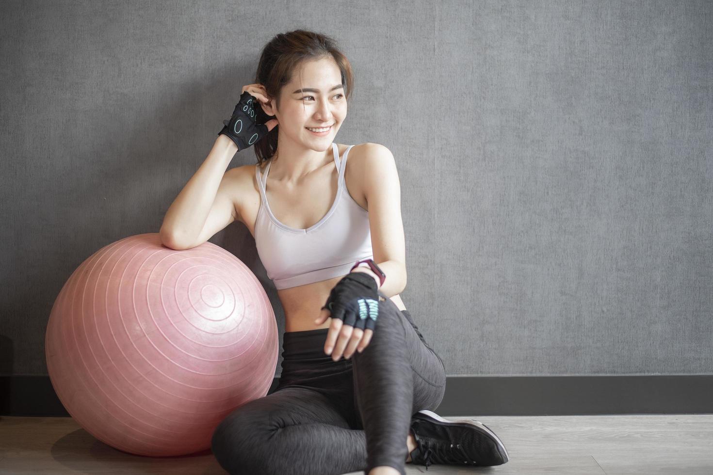Beautiful asian woman is doing exercise in the gym photo