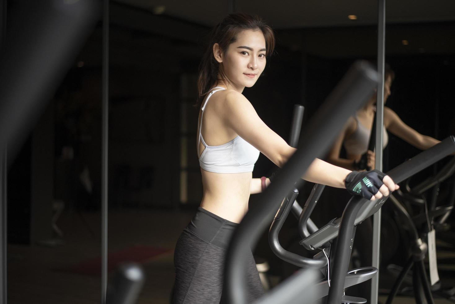 Beautiful asian woman is doing exercise in the gym photo