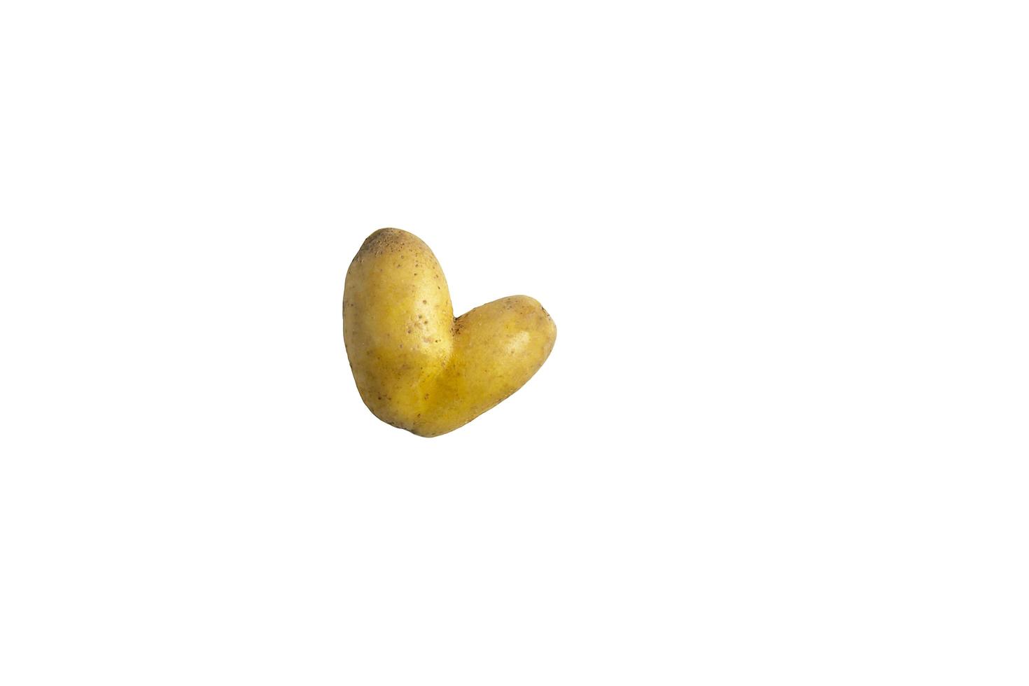 Raw potatoes in the shape of a heart on a white background photo