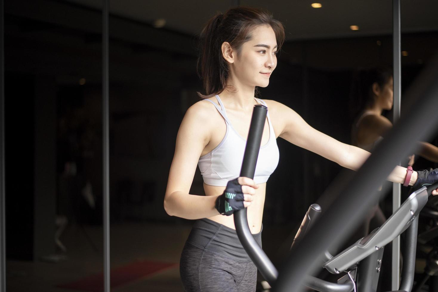 Beautiful asian woman is doing exercise in the gym photo