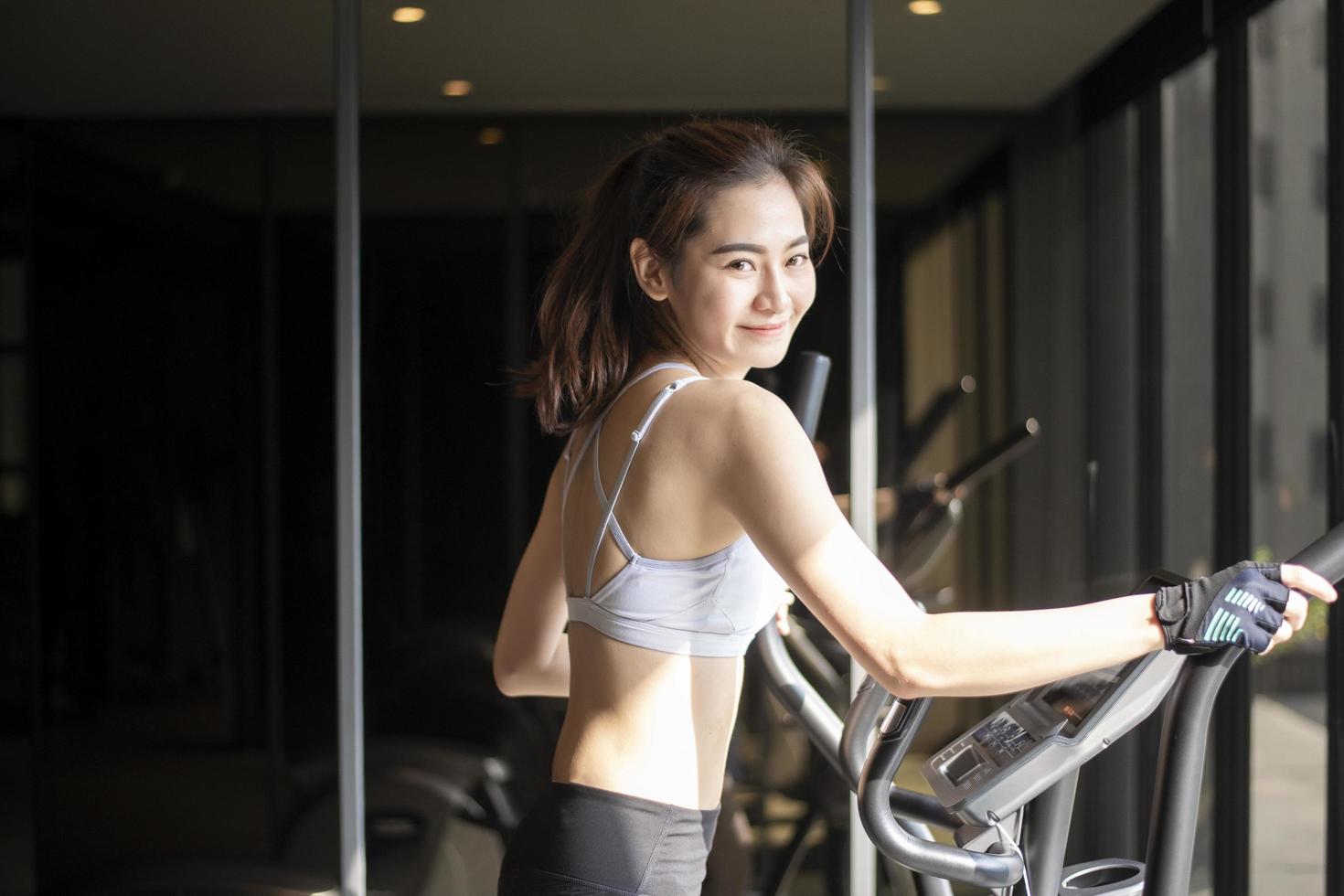 Beautiful asian woman is doing exercise in the gym photo