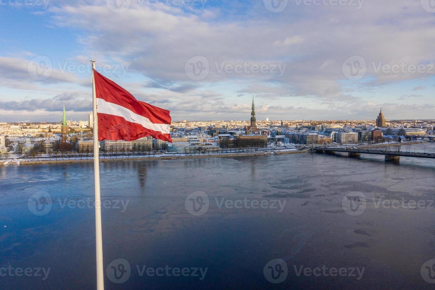 Panorama view of the Riga city with a big Latvian flag by the river Daugava. Latvian spirit. photo