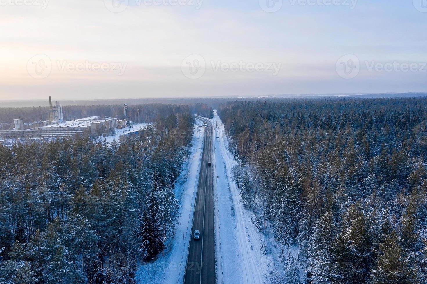 vista aérea de la carretera y el bosque en invierno. paisaje natural de invierno desde el aire. bosque bajo la nieve en invierno. paisaje de drone foto