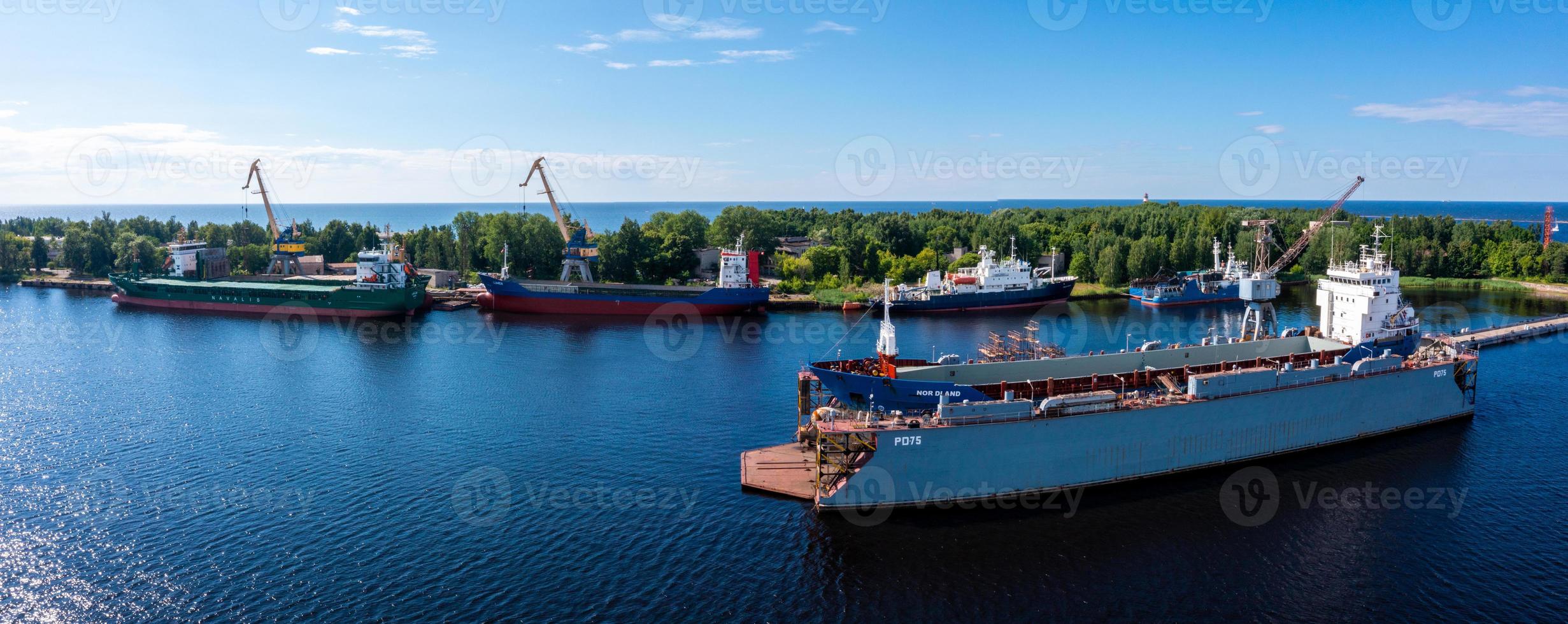 Riga, Latvia. June 10, 2021. Cargo ship at floating dry dock is being renovated photo