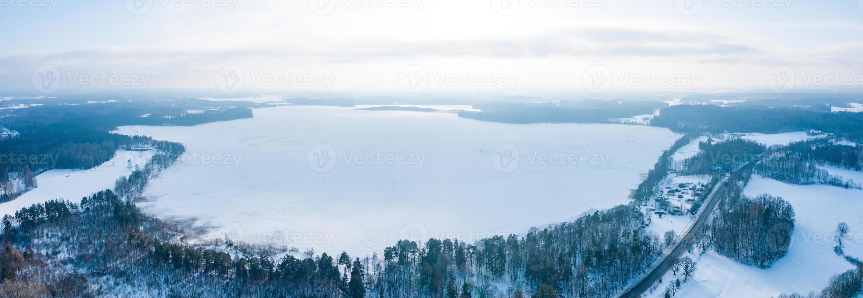 Aerial view of winter landscape, Panorama of the frozen lake in the middle of a forest. Winter wonderland. photo