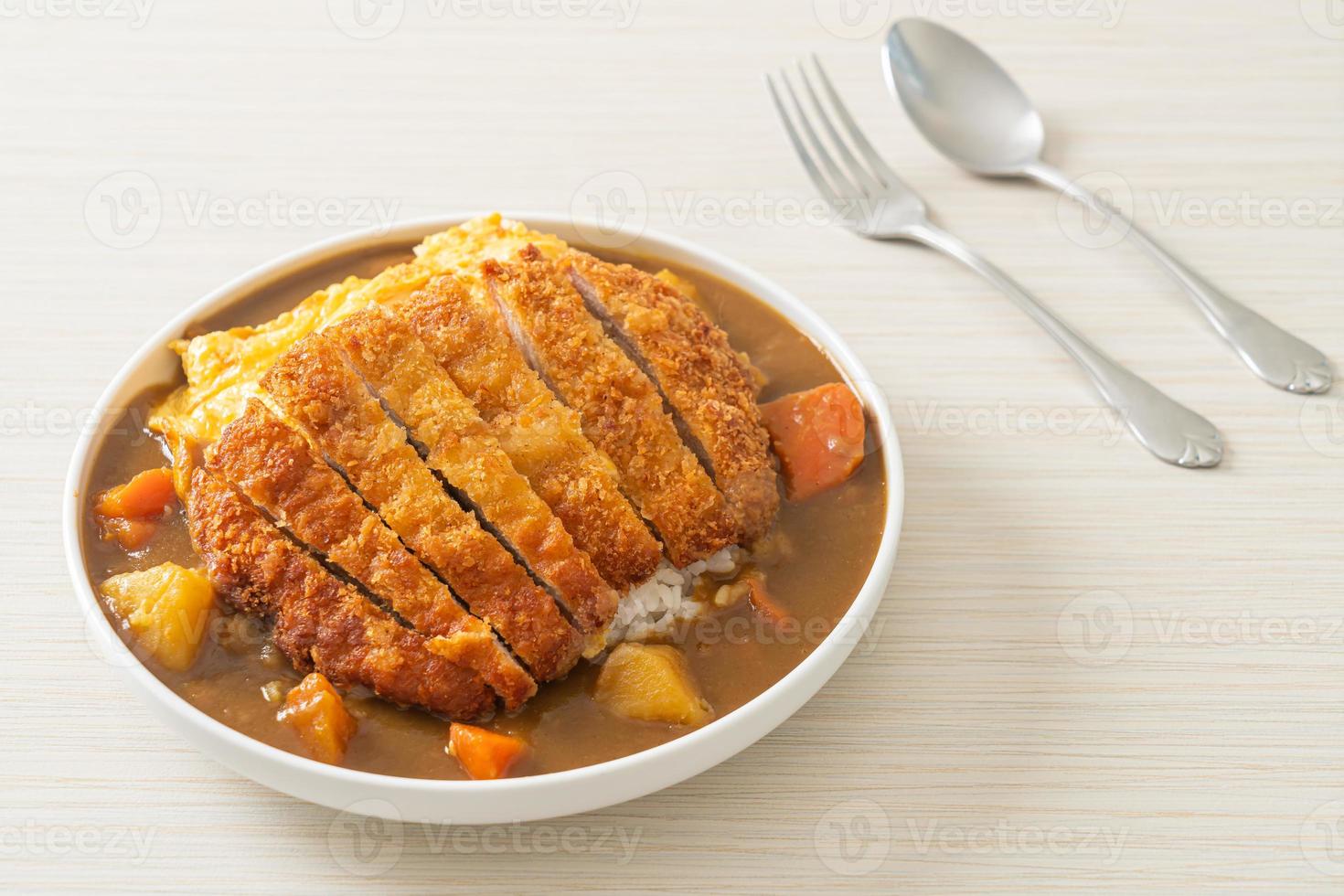 arroz al curry con chuleta de cerdo frita y tortilla cremosa foto