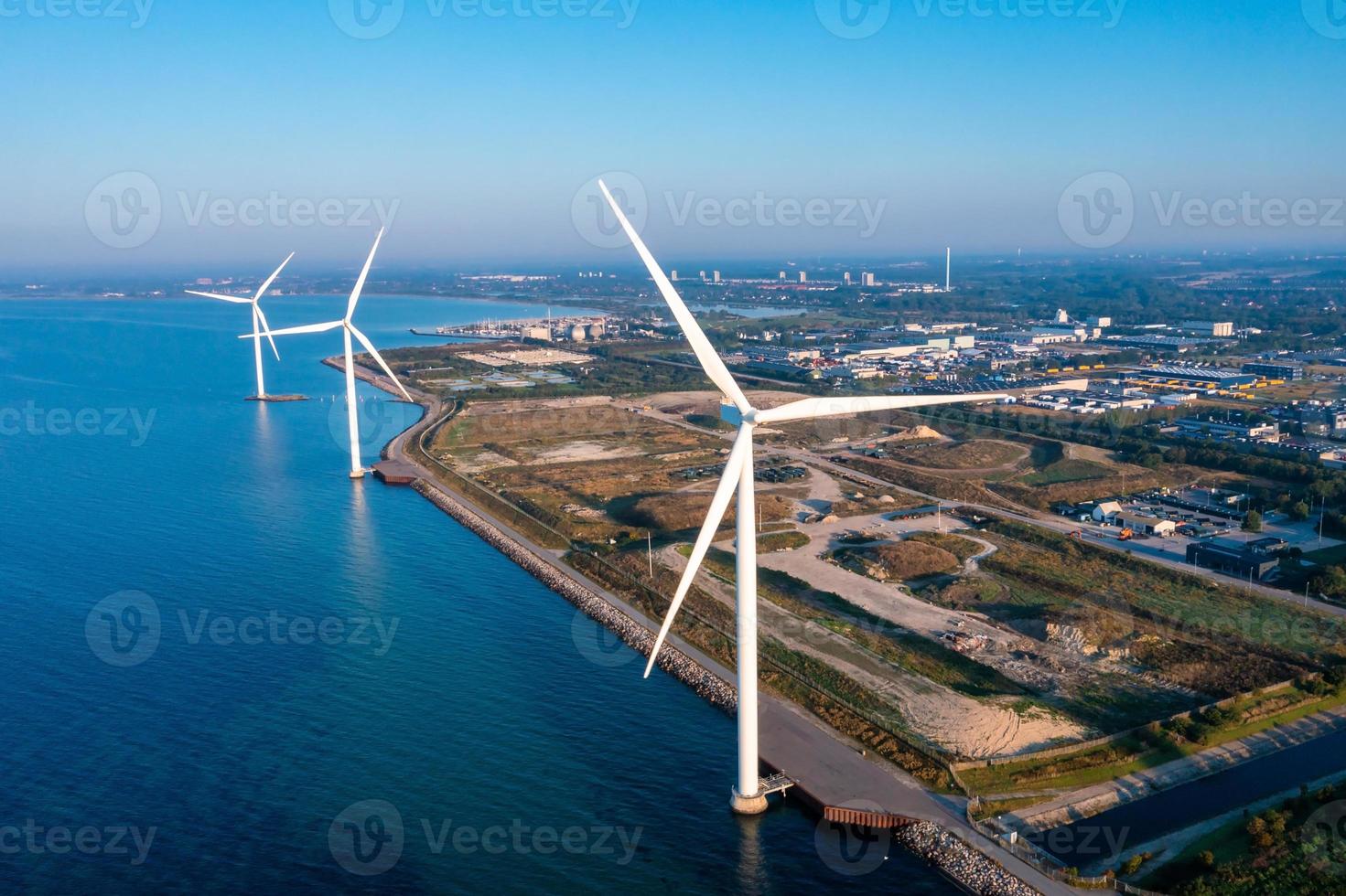 Aerial view of the wind turbines. Green ecological power energy generation. Wind farm eco field. Offshore and onshore windmill farm green energy at sea photo