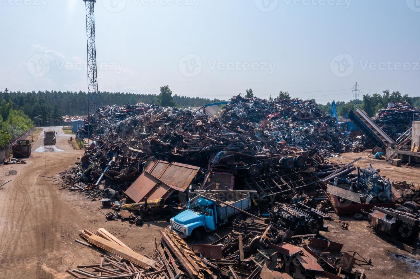 Old damaged cars on the junkyard waiting for recycling photo