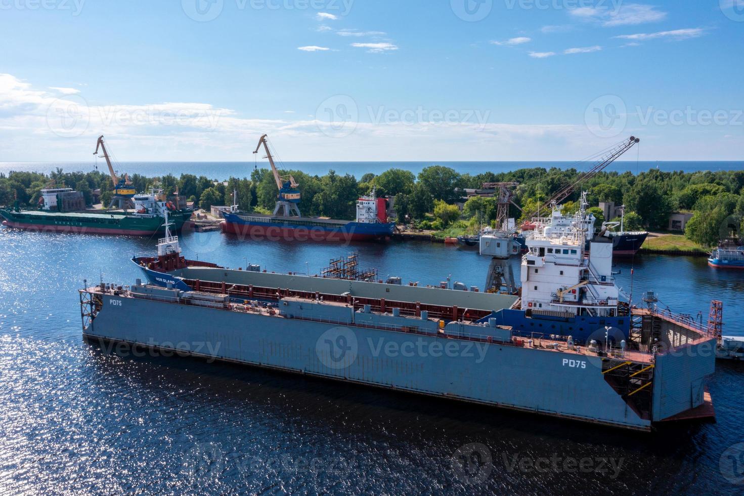 Riga, Latvia. June 10, 2021. Cargo ship at floating dry dock is being renovated photo