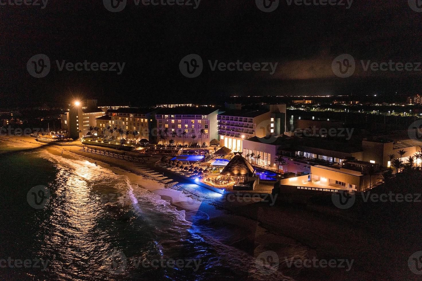 vista aérea del hotel de lujo por la noche junto al mar con una enorme piscina infinita. foto