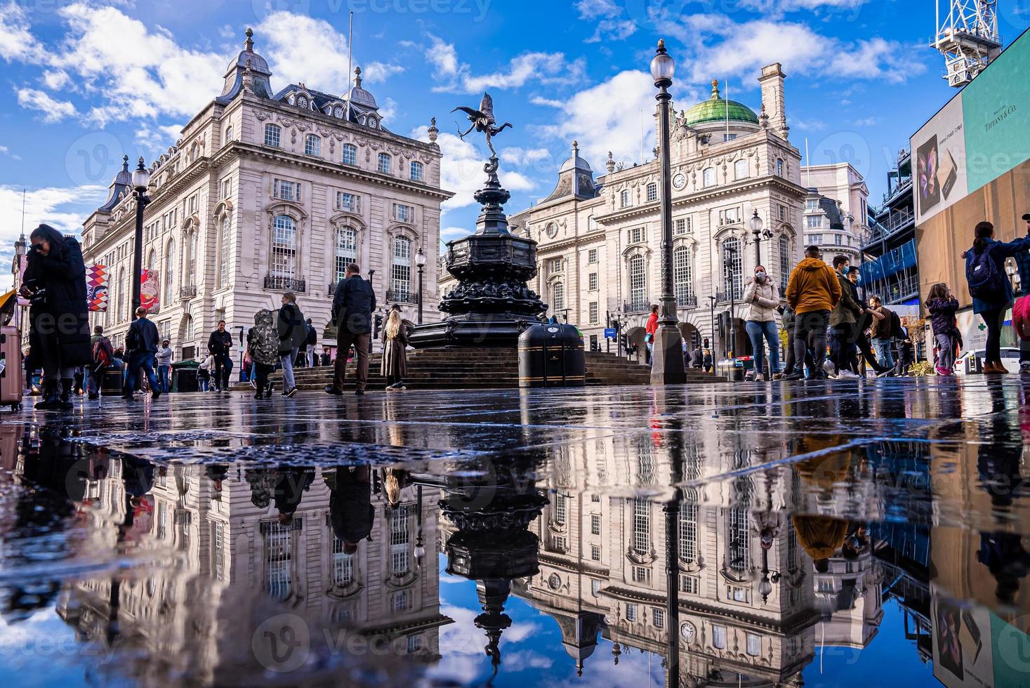 gente y tráfico en picadilly circus en londres después de la lluvia. foto