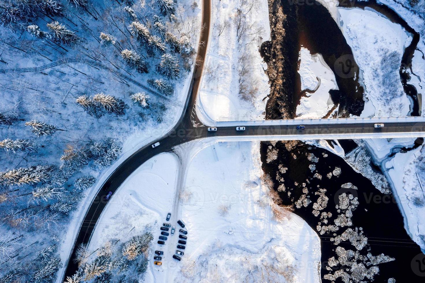 camino ventoso con curvas en el bosque cubierto de nieve, vista aérea de arriba hacia abajo. foto