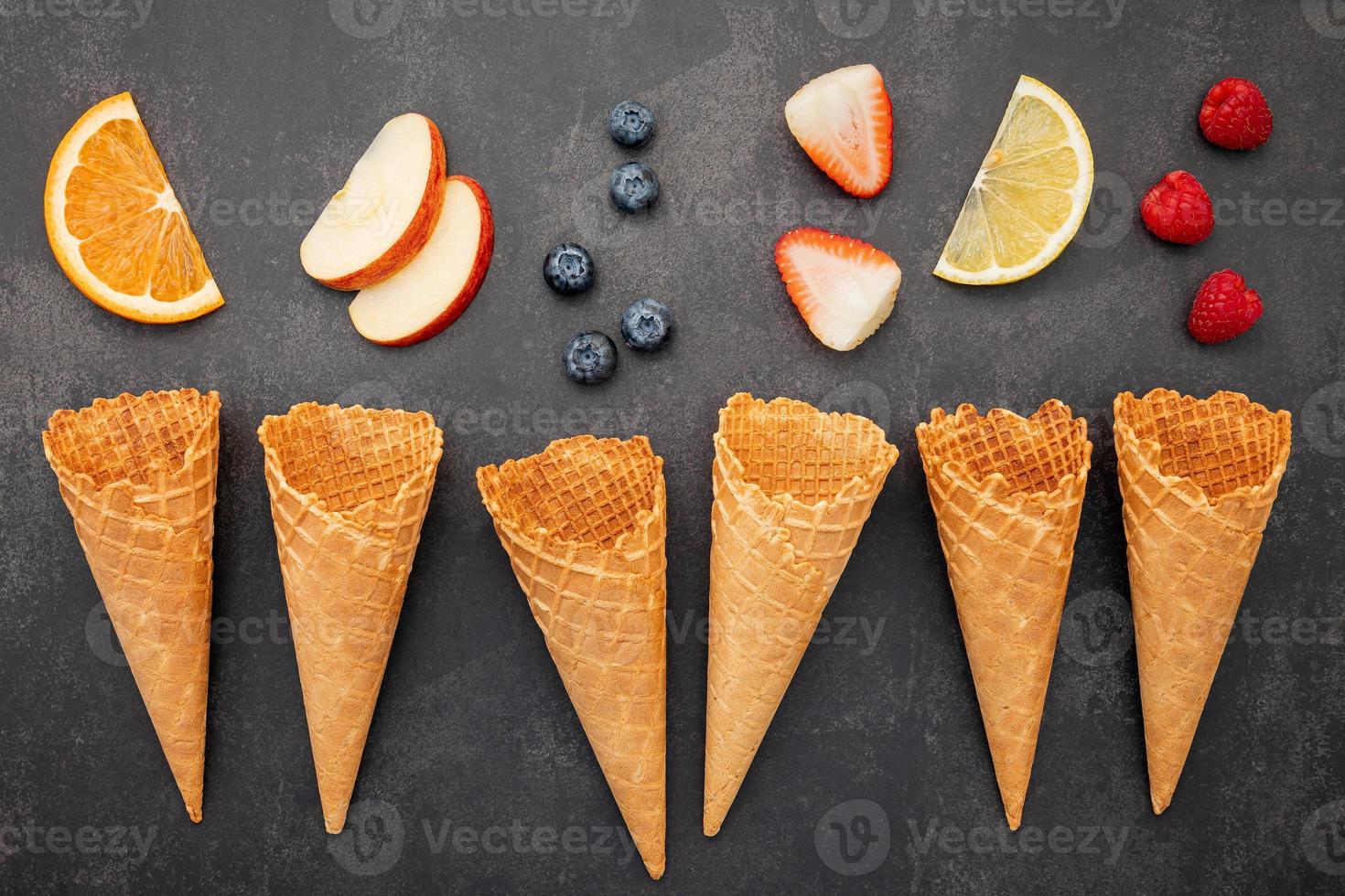 Flat lay ice cream cones collection on dark stone background . Blank crispy ice cream cone with copy space for sweets menu design. photo