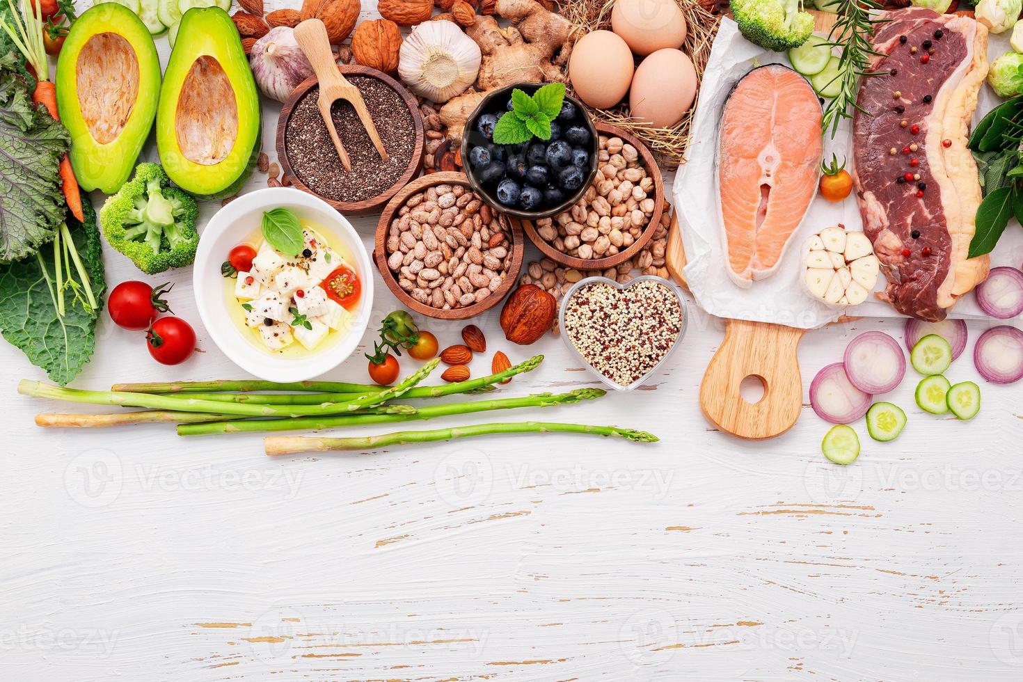 concepto de dieta cetogénica baja en carbohidratos. ingredientes para la selección de alimentos saludables sobre fondo blanco de madera. foto