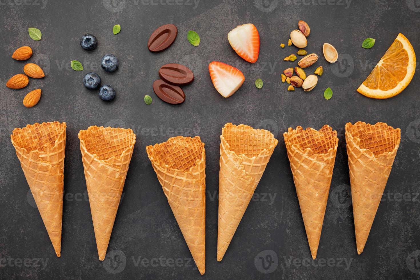 Flat lay ice cream cones collection on dark stone background . Blank crispy ice cream cone with copy space for sweets menu design. photo