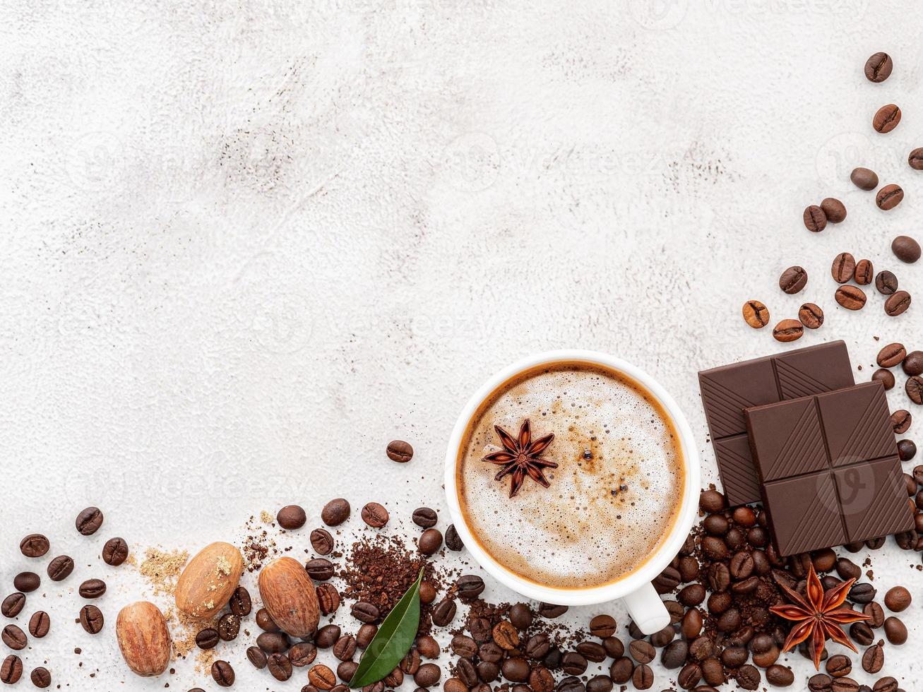 Background of dark roasted coffee bean and with dark chocolate on white concrete background with copy space. photo