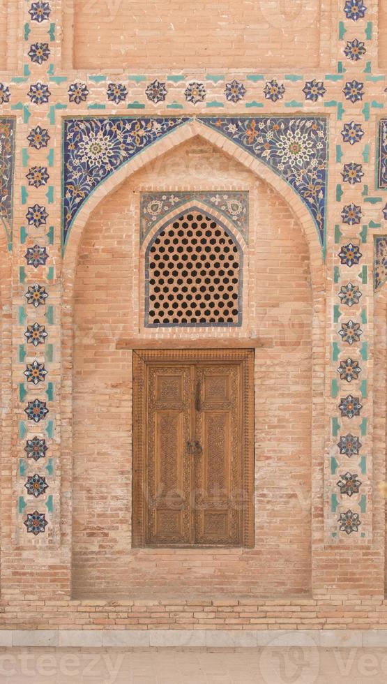 puerta de madera con antigua ornamentación asiática tradicional y mosaicos. los detalles de la arquitectura de asia central medieval foto