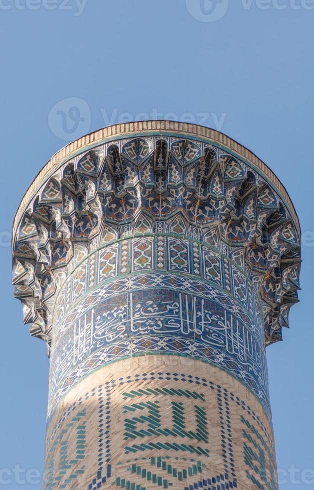 The top of the tower with a mosaic of quite ancient Asian buildings. the details of the architecture of medieval Central Asia photo