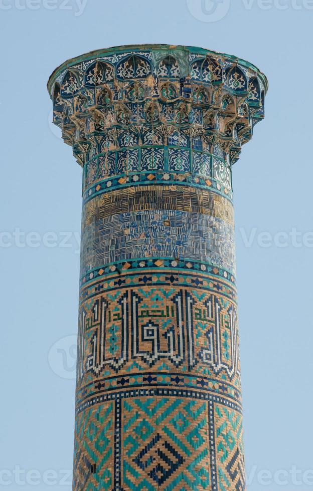 Closeup of the top of the tower with a mosaic of quite ancient Asian buildings. the details of the architecture of medieval Central Asia photo