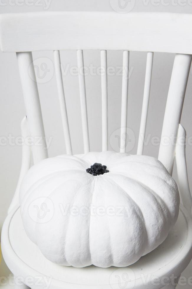 halloween y una calabaza blanca en una silla sobre un fondo blanco foto