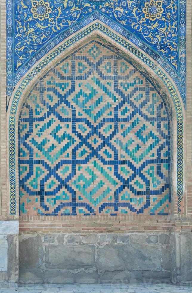 Wall with an arch in traditional Asian mosaic. the details of the architecture of medieval Central Asia photo