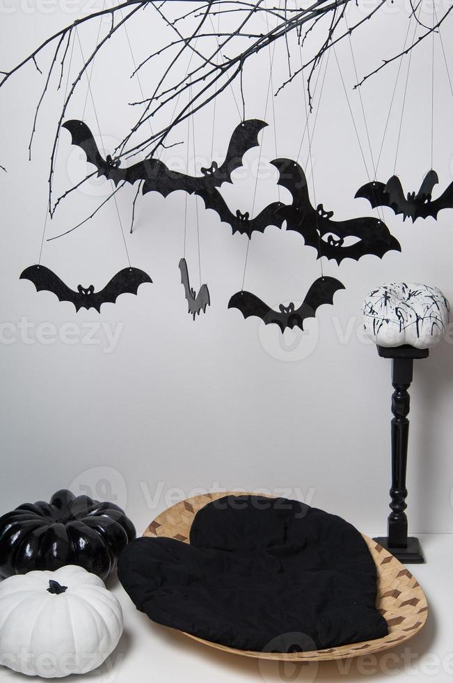 halloween silhouettes with many black bats on a tree branch and a pumpkin on a white background photo