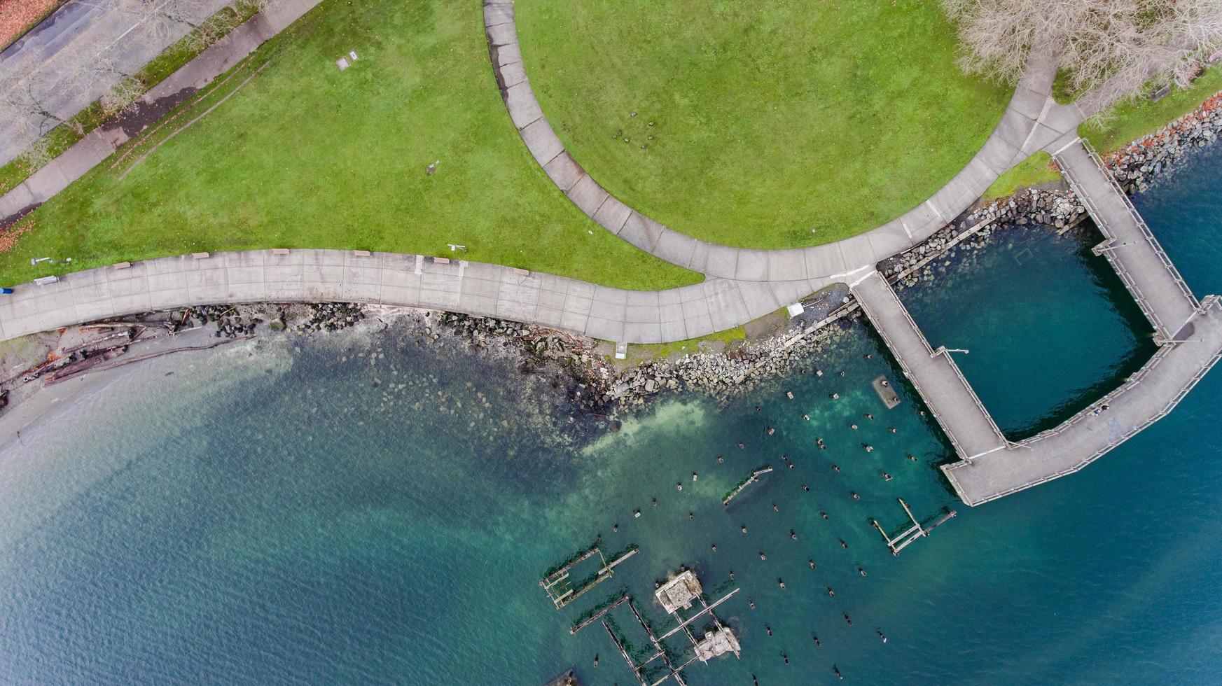 Aerial photo of waterfront park with piers and green grass