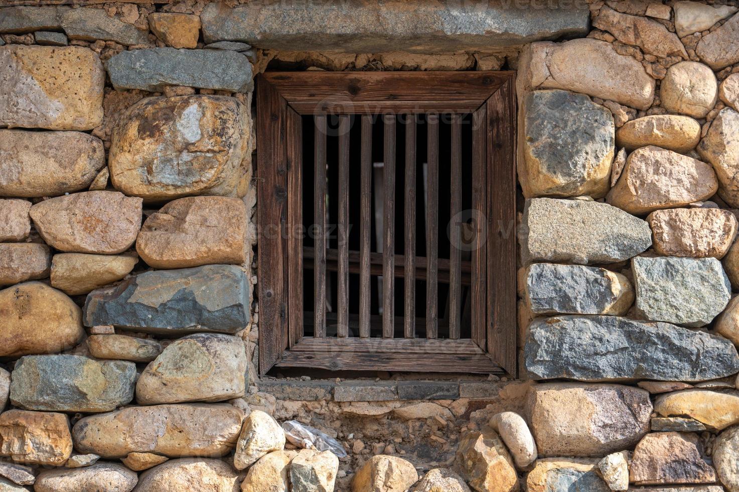 There is a window on the stone wall photo