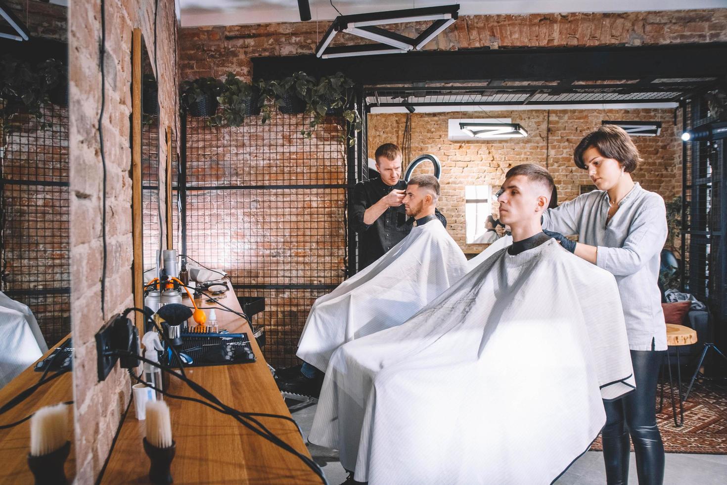 Hairdressers cut their clients in barbershop. Advertising and barber shop concept photo