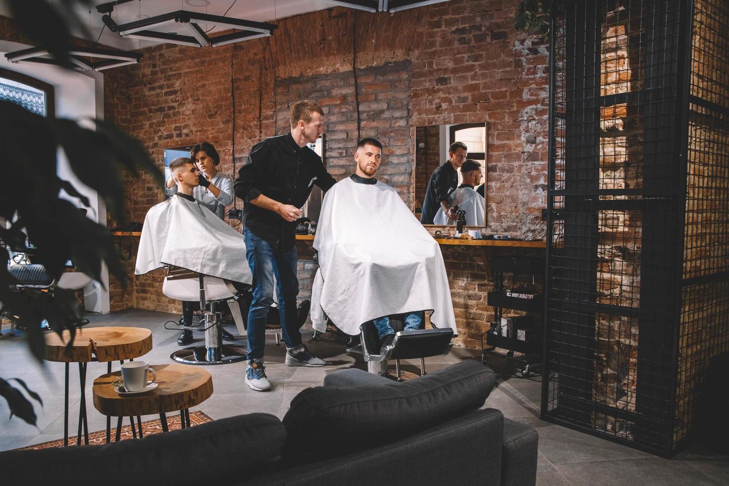 Hairdressers cut their clients in barbershop. Advertising and barber shop concept photo