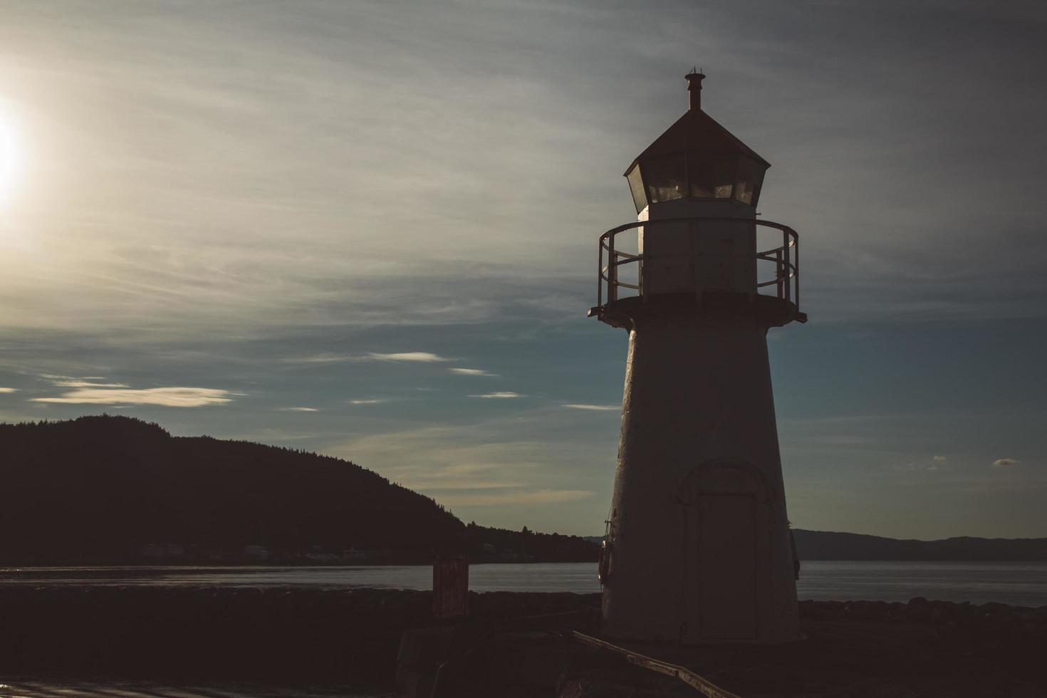 Lighthouse in silhouette at sunset and dramatic sky. Place for text or advertising photo