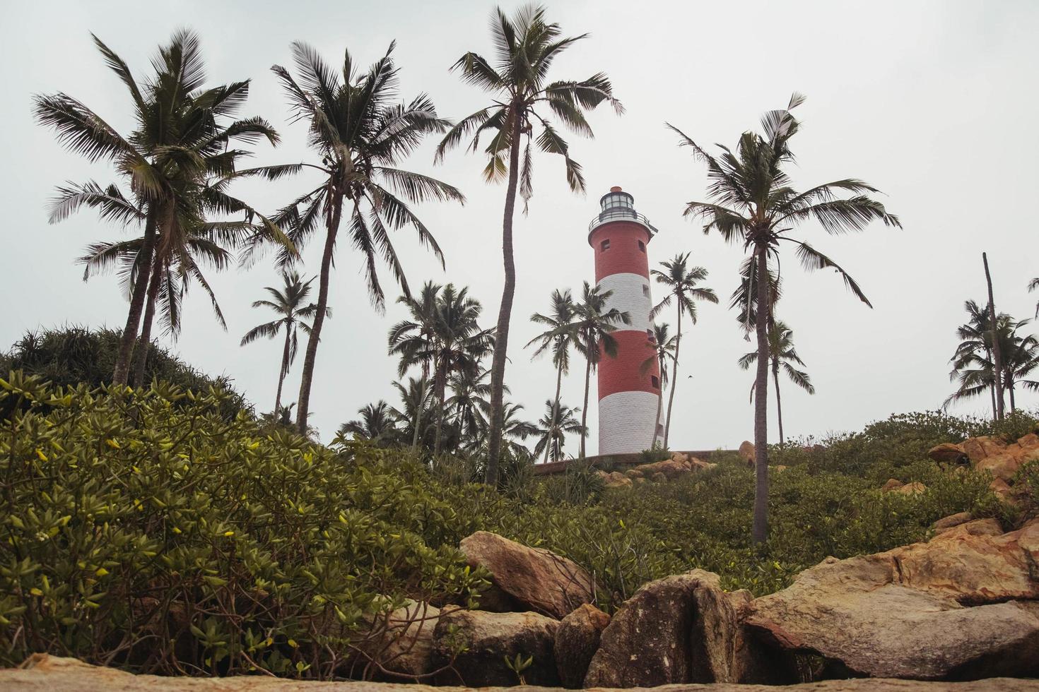 Lighthouse on the beach at morning dramatic sky in Kovalam, Kerala, India. Copy, empty space for text photo