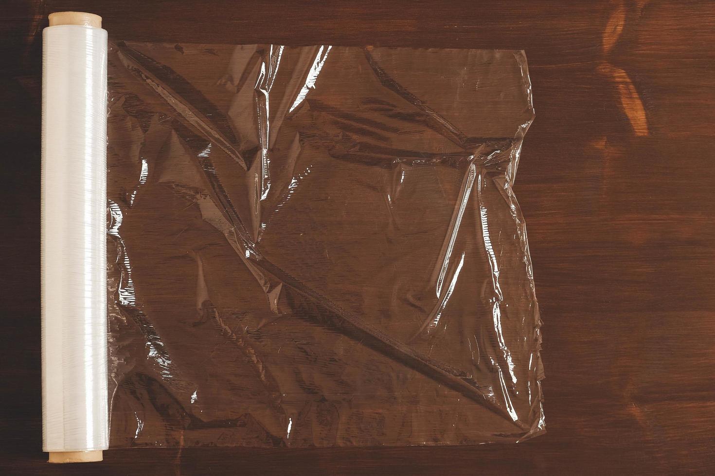 Big roll of transparent packaging film on a wooden background photo