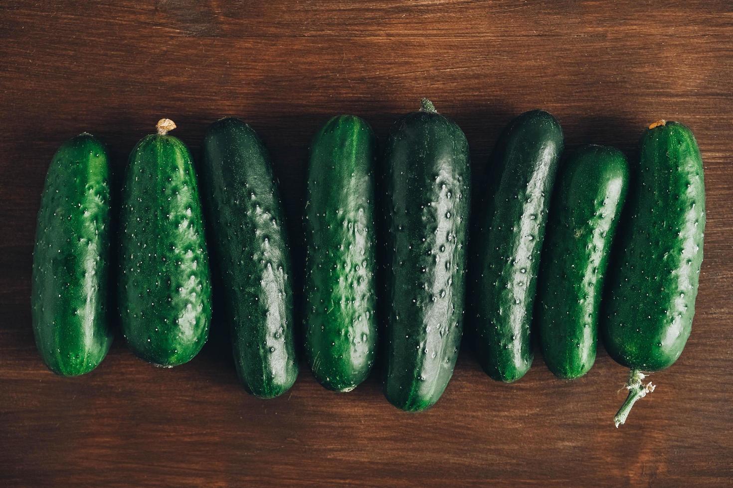 Fresh green cucumbers on a wooden table background. Top view. Copy, empty space for text photo