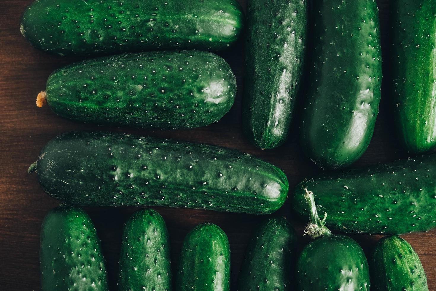 Fresh green cucumbers on a wooden table background. Top view. Copy, empty space for text photo