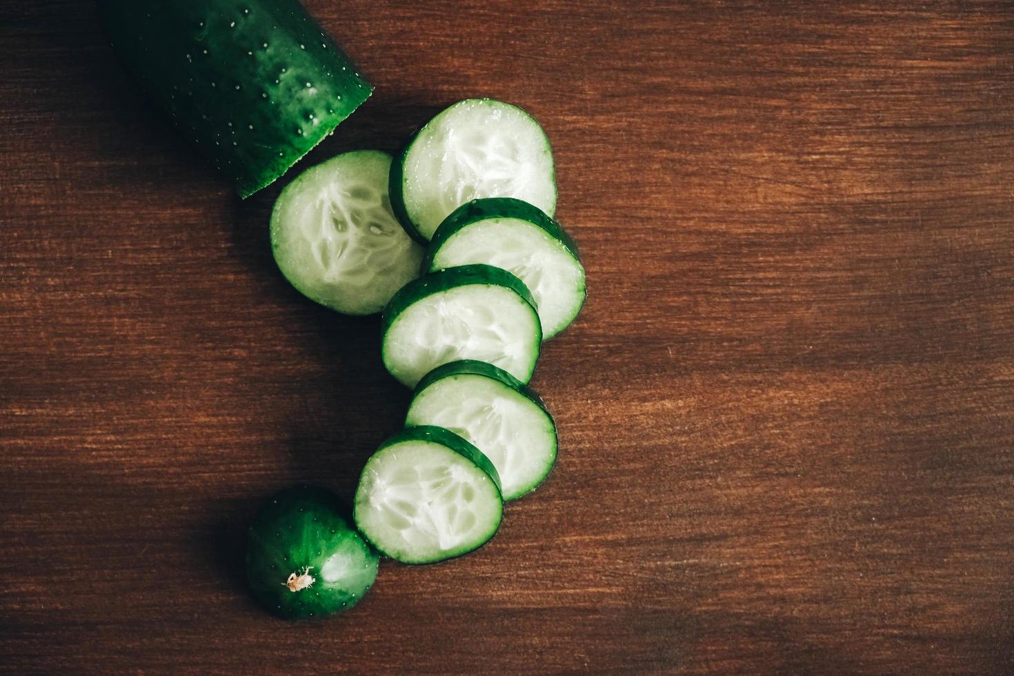 rodajas de pepino fresco sobre un fondo de madera. vista superior. copiar, espacio vacío para texto foto