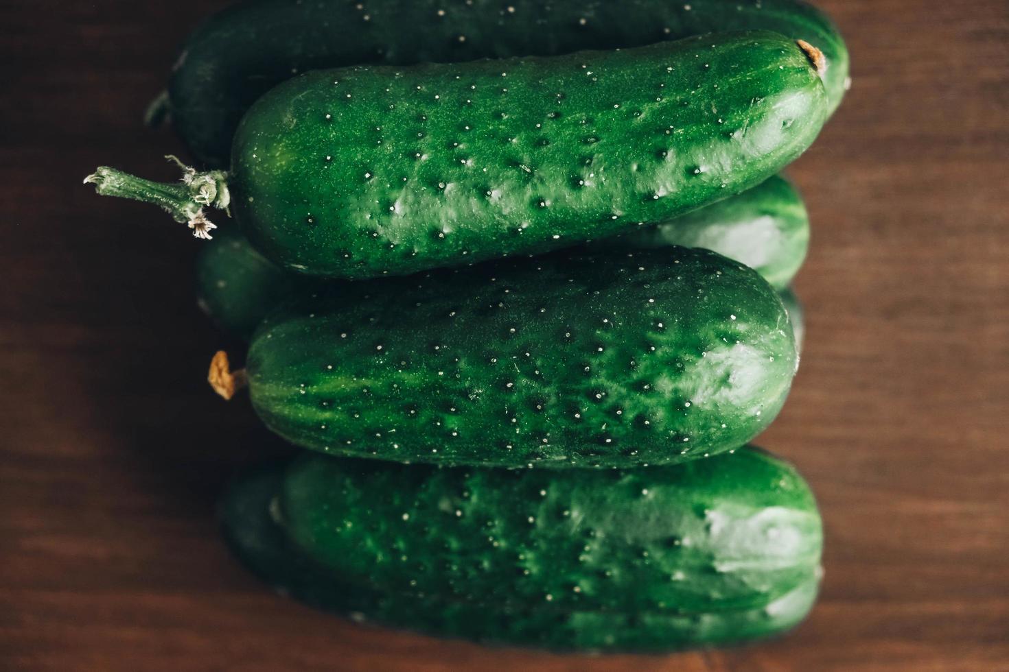 Fresh green cucumbers on a wooden table background. Top view. Copy, empty space for text photo