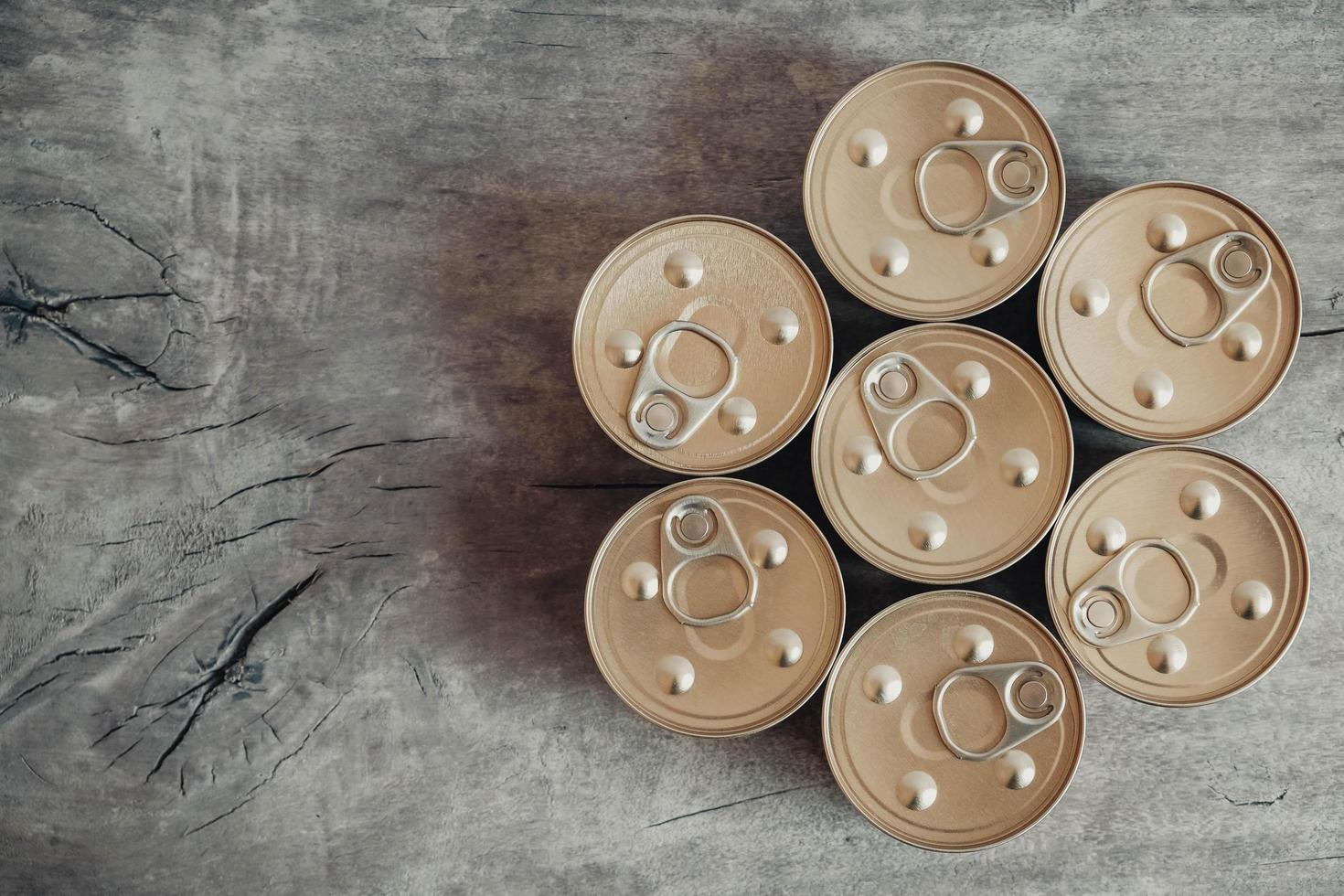 Metal closed canned food on a wooden background photo