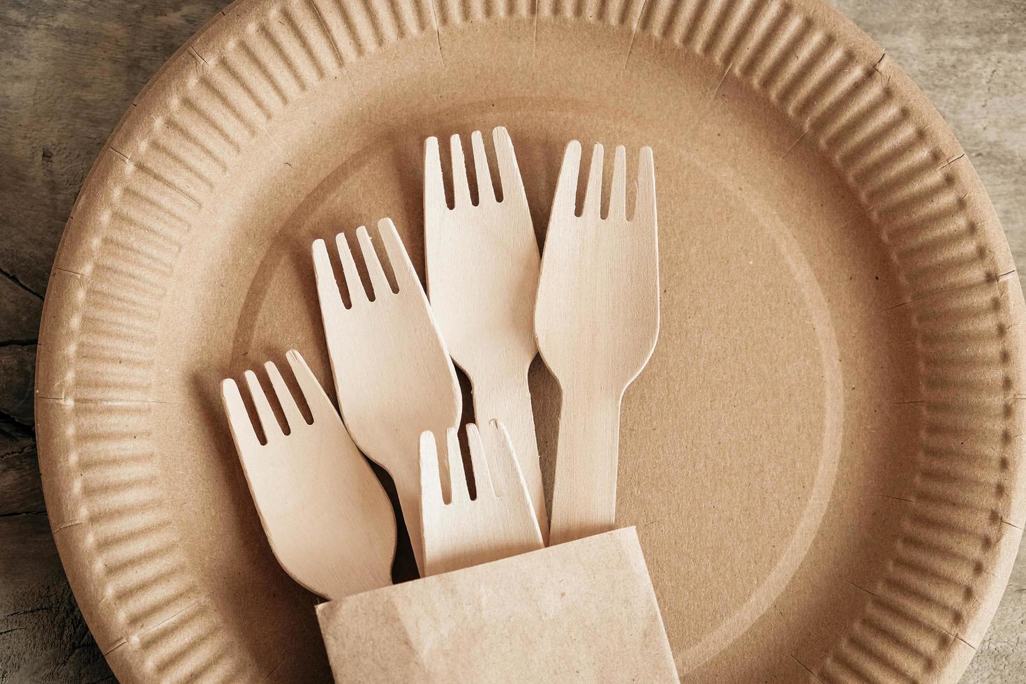 tenedores y platos de madera sobre fondo de madera foto