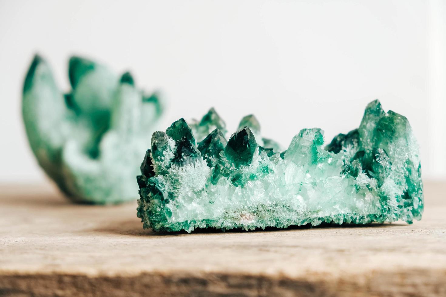 Esmeralda cruda y cristal de roca en bruto de piedras preciosas sobre una mesa de madera foto