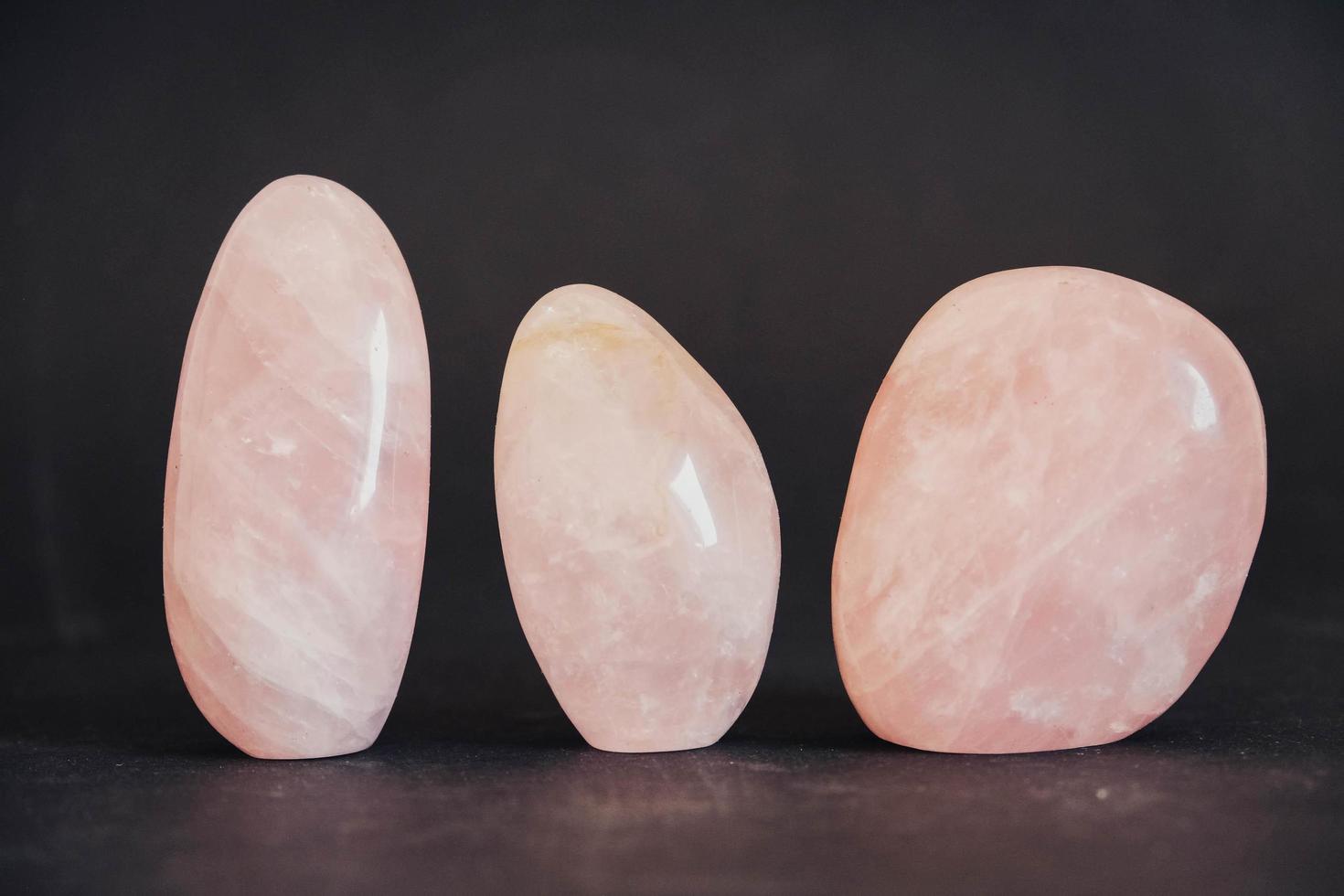 Polished crystals rose quartz gemstone on black background photo