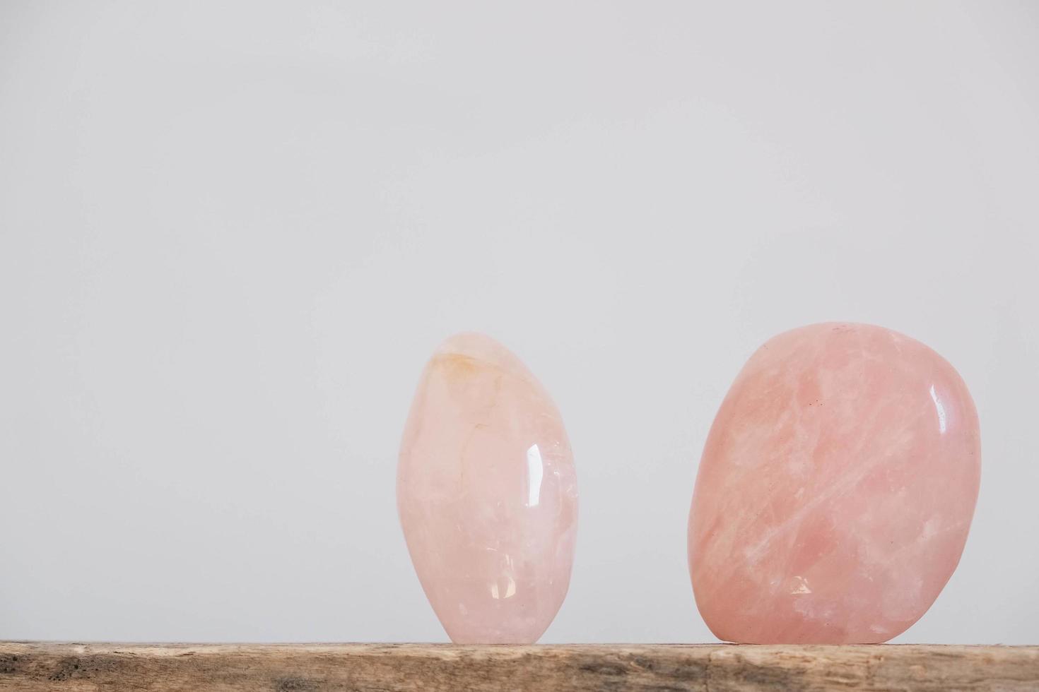 Polished crystals rose quartz gemstone on a wooden table photo